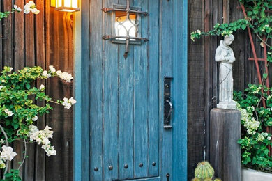 Idée de décoration pour une entrée chalet avec une porte simple et une porte bleue.