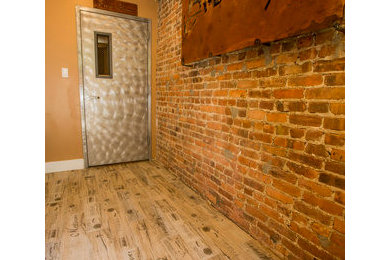 Diseño de hall rural de tamaño medio con paredes marrones, suelo de baldosas de porcelana, puerta pivotante y puerta metalizada