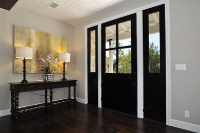 На фото: входная дверь среднего размера в стиле неоклассика (современная классика) с серыми стенами, темным паркетным полом и входной дверью из темного дерева с
