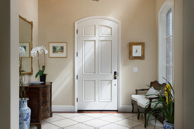 Entryway - large transitional dark wood floor entryway idea in San Diego with beige walls and a white front door