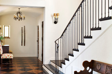 Example of a tuscan painted wood floor and multicolored floor entryway design in Los Angeles with white walls