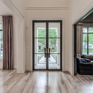 Foto di un ampio ingresso o corridoio classico con pareti bianche, parquet chiaro, una porta a due ante, una porta in metallo e pavimento beige
