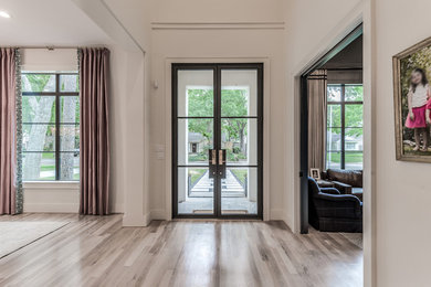 Example of a huge transitional light wood floor and beige floor double front door design in Houston with white walls and a metal front door
