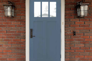 Ejemplo de puerta principal de estilo americano con paredes rojas, suelo de cemento, puerta simple, puerta azul, suelo gris, madera y madera