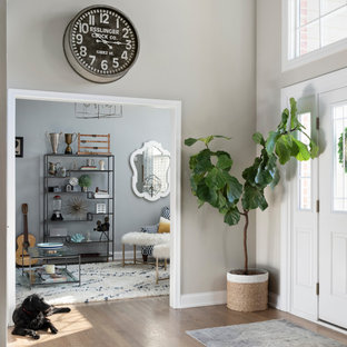 Modelo de distribuidor abovedado, tradicional renovado, extra grande, con paredes grises, suelo de madera en tonos medios, puerta simple, puerta blanca y suelo gris