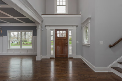 Example of a mid-sized classic dark wood floor and brown floor entryway design in Bridgeport with gray walls and a medium wood front door