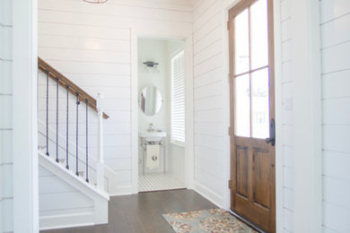 Farmhouse medium tone wood floor entryway photo in Austin with white walls and a dark wood front door