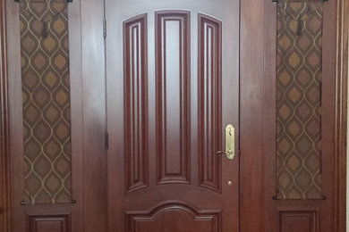 Diseño de entrada clásica con suelo de madera en tonos medios y puerta de madera en tonos medios