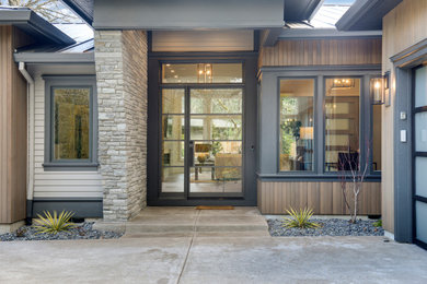 Diseño de puerta principal moderna grande con paredes grises, suelo de madera clara, puerta simple, puerta metalizada y suelo gris