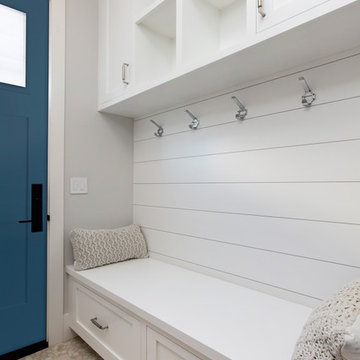 Simple Mudroom with Shiplap, a wood bench, and a Blue Door
