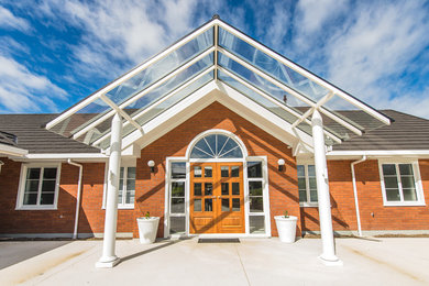 Example of a large classic concrete floor entryway design in Other