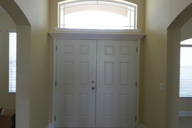 タンパにある小さなトラディショナルスタイルのおしゃれな玄関ドア (ベージュの壁、白いドア、ベージュの床) の写真