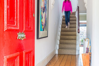 Источник вдохновения для домашнего уюта: входная дверь в стиле фьюжн с одностворчатой входной дверью, красной входной дверью, белыми стенами и светлым паркетным полом