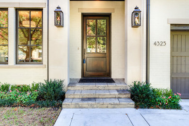 This is an example of a medium sized traditional front door in Dallas with white walls, concrete flooring, a single front door and a brown front door.