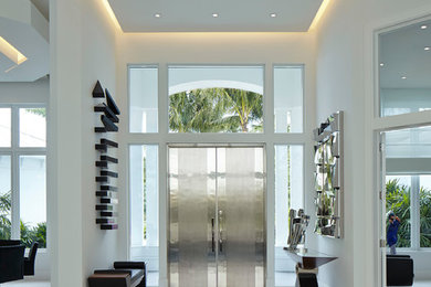 マイアミにあるコンテンポラリースタイルのおしゃれな玄関ロビー (白い壁、磁器タイルの床、金属製ドア) の写真