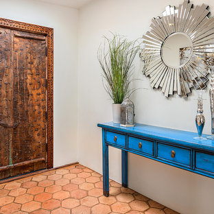Immagine di un ingresso o corridoio bohémian con una porta a due ante, una porta in legno bruno e pavimento arancione