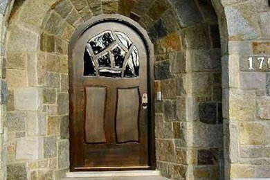 Ejemplo de puerta principal tradicional grande con paredes marrones, suelo de piedra caliza, puerta de madera oscura y puerta simple