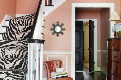 Inspiration for a traditional foyer in Charlotte with pink walls, dark hardwood flooring, a single front door and feature lighting.