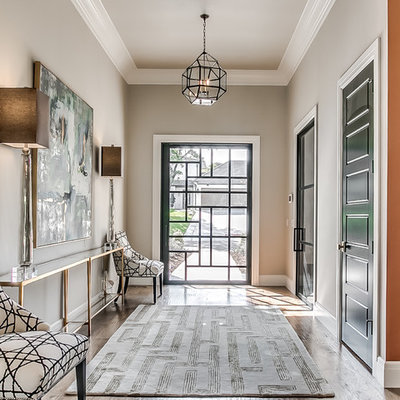 Example of a transitional medium tone wood floor and brown floor entryway design in Oklahoma City with gray walls and a glass front door