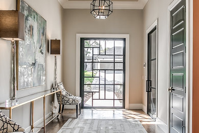 Example of a transitional medium tone wood floor and brown floor entryway design in Oklahoma City with gray walls and a glass front door