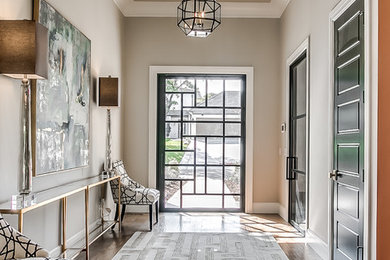 Inspiration pour un hall d'entrée traditionnel avec un mur gris, un sol en bois brun, une porte pivot, une porte en verre et un sol marron.