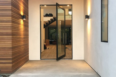 Large minimalist concrete floor entryway photo in Los Angeles with gray walls and a metal front door