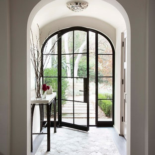 Esempio di un ingresso con vestibolo mediterraneo con pareti bianche, parquet scuro, una porta singola e una porta in vetro