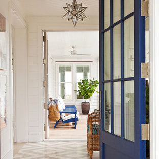 Maritime Haustür mit weißer Wandfarbe, gebeiztem Holzboden, Einzeltür und blauer Tür in Charleston