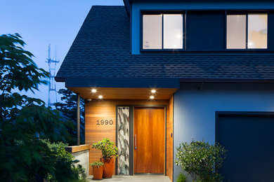 На фото: большая входная дверь в стиле модернизм с серыми стенами, полом из сланца, одностворчатой входной дверью и входной дверью из дерева среднего тона с