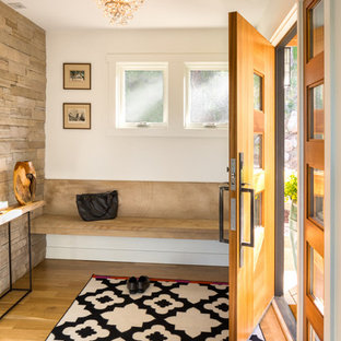 Foto de distribuidor actual con paredes blancas, suelo de madera clara, puerta simple y puerta de madera clara