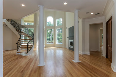 Large elegant light wood floor and beige floor foyer photo in Houston with white walls