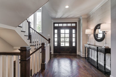 Large transitional medium tone wood floor and brown floor entryway photo in Baltimore with gray walls and a dark wood front door