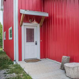 Esempio di una porta d'ingresso country di medie dimensioni con pareti rosse, pavimento in cemento, una porta singola e una porta bianca