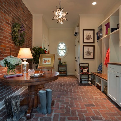 Country brick floor entryway photo in Other with white walls and a white front door