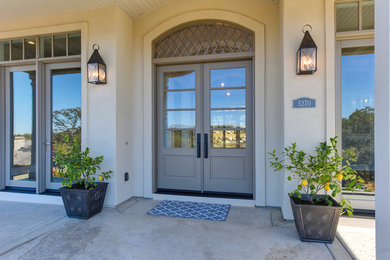 На фото: большая входная дверь в стиле неоклассика (современная классика) с серыми стенами, двустворчатой входной дверью и серой входной дверью