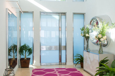 Großes Modernes Foyer mit Drehtür, weißer Wandfarbe, Travertin, Haustür aus Glas und beigem Boden in Tampa