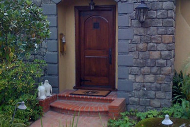 サンフランシスコにある低価格の小さなラスティックスタイルのおしゃれな玄関ドア (ベージュの壁、レンガの床、濃色木目調のドア、赤い床) の写真