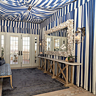 Aménagement d'une grand entrée exotique avec un couloir, un mur multicolore, moquette, une porte double, une porte blanche et un sol bleu.