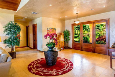 ハワイにある高級な広いトロピカルスタイルのおしゃれな玄関ロビー (ガラスドア、ベージュの壁、セラミックタイルの床、ベージュの床) の写真