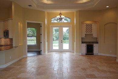 Example of a mid-sized tuscan travertine floor double front door design in Miami with a glass front door