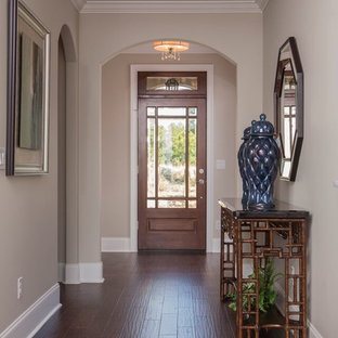 Imagen de puerta principal clásica, de tamaño medio, con paredes beige, suelo de madera oscura, puerta simple y puerta de vidrio