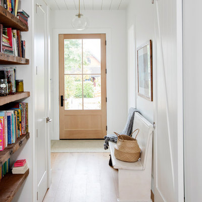 Inspiration for a country medium tone wood floor and brown floor single front door remodel in Vancouver with white walls and a light wood front door