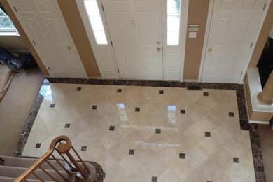 Inspiration for a small timeless marble floor entryway remodel in New York with beige walls and a light wood front door