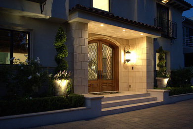 Example of a large tuscan entryway design in Los Angeles with a medium wood front door