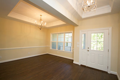 Example of a mid-sized classic dark wood floor entryway design in Richmond with yellow walls and a white front door