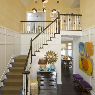 Example of a large classic dark wood floor foyer design in New York with yellow walls