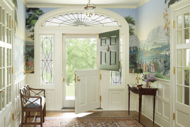 Inspiration for a mid-sized timeless medium tone wood floor entryway remodel in New York with multicolored walls and a green front door