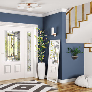 Idee per un grande ingresso classico con pareti blu, pavimento in legno massello medio, una porta singola, una porta bianca e pavimento marrone