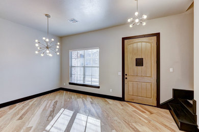 Example of a large transitional light wood floor and beige floor entryway design in Oklahoma City with gray walls and a light wood front door