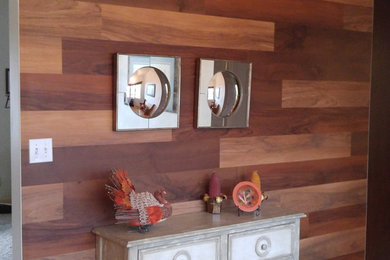 Example of a mid-sized light wood floor foyer design in Other with brown walls